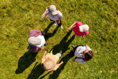 Yeşil çimlerin üzerinde daireler çizen insanların üst hava görüntüsü. Drone fotoğrafçılığı