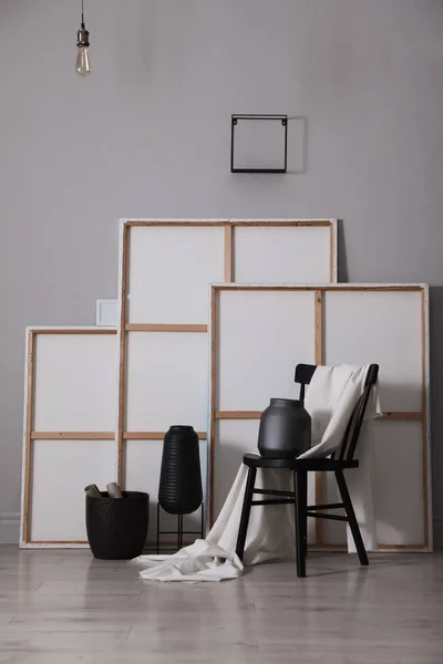 Cadeira Com Tecido Branco Vasos Pinturas Perto Parede Cinza Estúdio — Fotografia de Stock