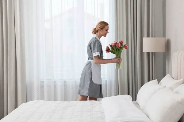 客室メイドで新鮮な花でホテルのベッドルーム — ストック写真