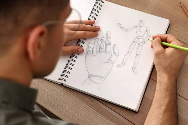 木のテーブルで鉛筆でスケッチブックを描く男 クローズアップ — ストック写真