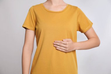 Gri arka planda karın yakınında el ele tutuşan kadın, yakın plan.