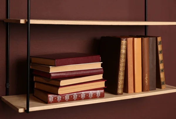 Półki Różnymi Książkami Brązowej Ścianie Zbliżenie — Zdjęcie stockowe