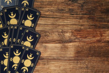 Tarot kartları ahşap masada, üst görünüm ve metin için boşluk. Ters taraf