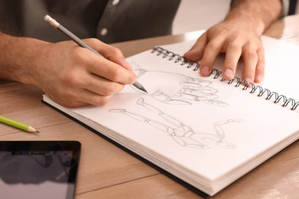 Человек Рисует Альбоме Карандашом Деревянным Столом Крупным Планом — стоковое фото