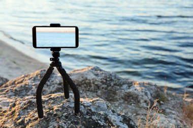 Rocky River Sahili 'nde akıllı telefonları olan tripodlar. Metin için boşluk