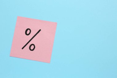 Açık mavi zemin üzerinde yüzde işareti olan kağıt not, üst görünüm. Metin için boşluk