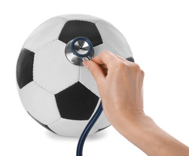 Beyaz arka planda steteskoplu bir kadın futbol topunu inceliyor, yakın plan. Doping kavramı