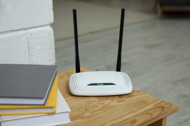 Odanın ahşap masasında Wi-Fi yönlendirici var.