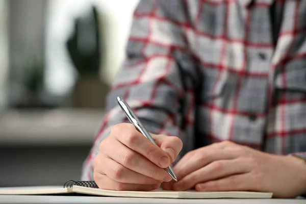 ノートパッドにペンで書く女性テーブルの屋内 クローズアップ — ストック写真