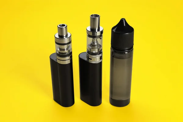 Neue Wiederverwendbare Elektronische Zigaretten Und Dampfende Flüssigkeit Auf Gelbem Hintergrund — Stockfoto