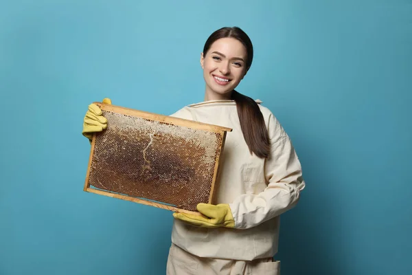 養蜂家で均一な保持じんましんフレームとともにハニカムオンライトブルーの背景 — ストック写真