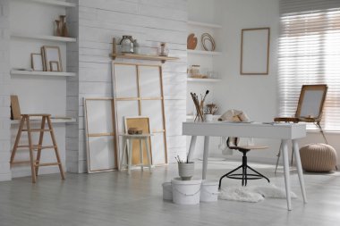 Sanatçının iş yeri ve sanat malzemeleriyle modern stüdyo içi