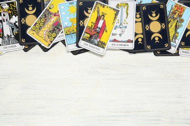 Tarot kartları beyaz ahşap masada, üst manzara. Metin için boşluk.