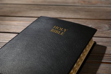 Ahşap masanın üzerinde eski bir İncil, yakın plan. Dini kitap