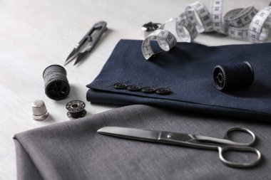 Beyaz masada dikiş malzemeleri ve aksesuarlar var.