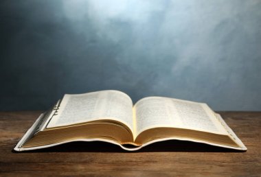 İncil 'i ahşap masada renk arkaplanına karşı açın. Hıristiyan dini kitabı