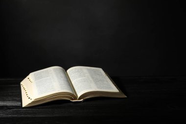 Siyah ahşap masada İncil 'i aç, yazı için yer aç. Hıristiyan dini kitabı