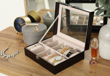 Güzel bijouterie ile zarif mücevher kutusu ve ahşap masa üzerinde lüks parfüm yanında pahalı kol saatleri