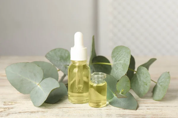 Bottles Eucalyptus Essential Oil Plant Branches White Wooden Table — Stock Photo, Image