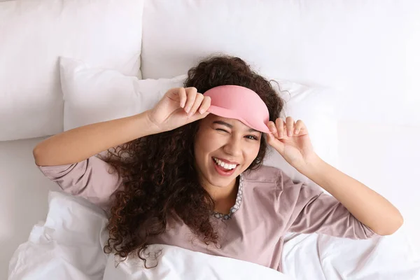 幸せなアフリカ系アメリカ人女性と睡眠マスクでベッド トップビュー — ストック写真