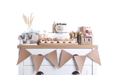 Bebek partisi. Göğüs çekmecesinde farklı lezzetler ve beyaz arka planda farklı dekorlar.