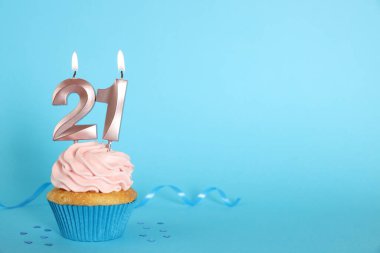 Açık mavi arkaplanda numara şekilli mumları olan enfes bir kek. Mesaj için yer var. Reşit olma partisi - 21. yaş günü