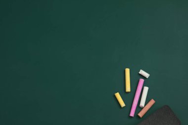 Yeşil tahtada renkli tebeşir ve toz bezi, düz. Metin için boşluk