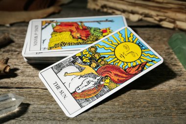 Güneş ve diğer tarot kartları ahşap masada, yakın plan.