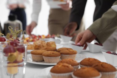 Kahve molasında farklı lezzetli atıştırmalıkları olan insanlar, yakın çekim.