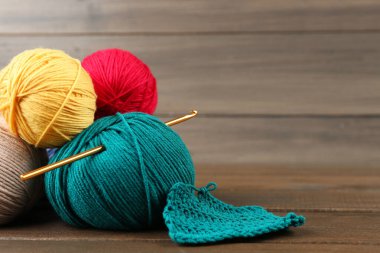 Renkli örgü iplikleri ve ahşap masaya örgü kancası, metin için boşluk