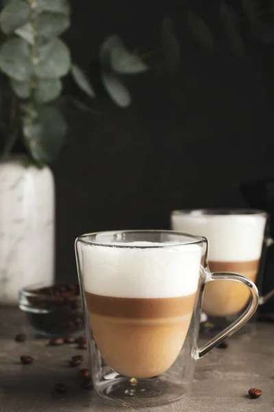 Glass Cups Delicious Latte Macchiato Scattered Coffee Beans Grey Table — Stock Photo, Image