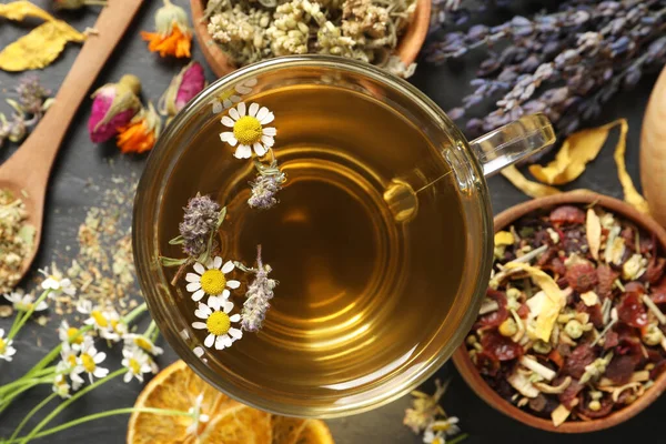 Szklana Filiżanka Aromatycznej Świeżo Parzonej Herbaty Pobliżu Różnych Suchych Ziół — Zdjęcie stockowe