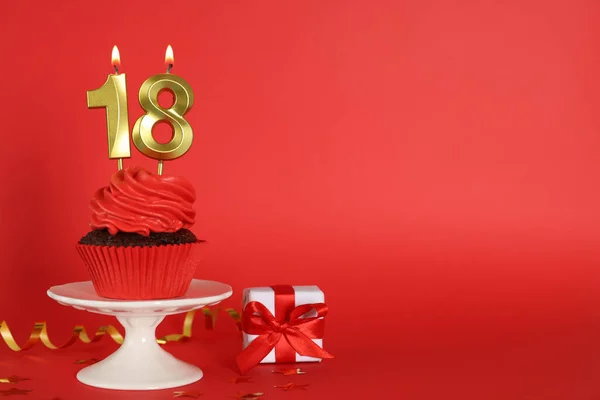 赤い背景に数形のキャンドルとおいしいカップケーキ テキストのためのスペース 成人パーティーのお知らせ 18歳の誕生日 — ストック写真