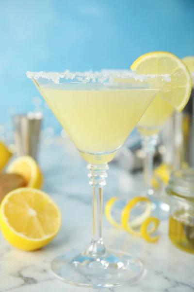 stock image Delicious bee's knees cocktail and ingredients on white marble table against light blue background