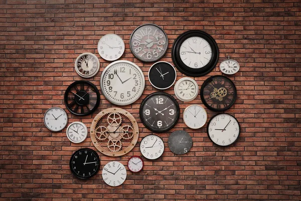 Kolekcja Zegarów Wiszących Ścianie Czerwonej Cegły — Zdjęcie stockowe