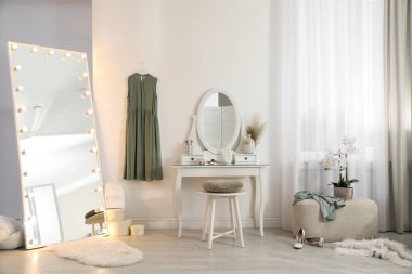 Moda odasında ampulleri ve tuvalet masası olan büyük bir ayna. İç tasarım