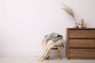 Modern çekmeceler ve beyaz duvarın yanındaki tabure. Metin için boşluk