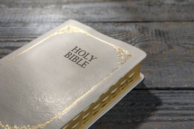 Gri ahşap masada eski bir İncil, yakın plan. Dini kitap