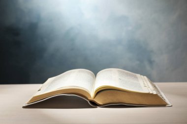 Beyaz ahşap masa üzerindeki İncil 'i renk arkaplanına karşı aç. Hıristiyan dini kitabı