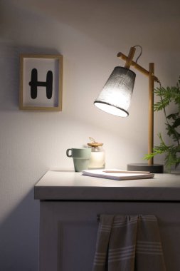 Beyaz dolapta şık bir lamba ve dekor var. İç öge