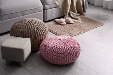 Oturma odasındaki kanepenin yanında puf ve kanepe var. İç öge