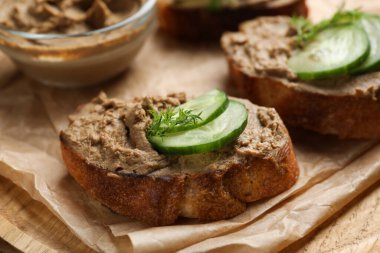 Tahta tabakta lezzetli ezmeli, salatalıklı ve dereotlu ekmek dilimleri, yakın plan.