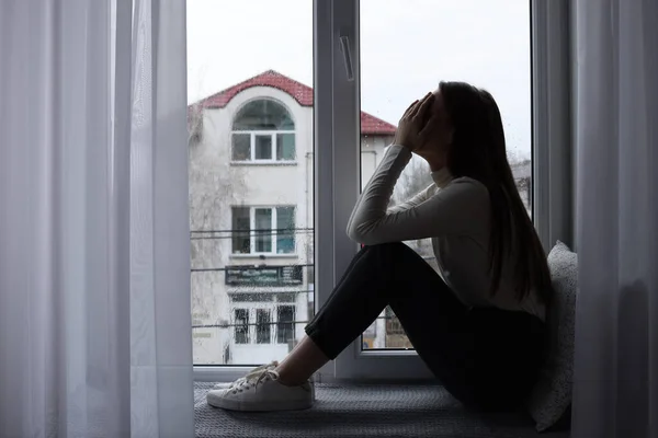 窓のそばで泣いている不幸な若い女性 テキストのためのスペース 孤独の概念 — ストック写真