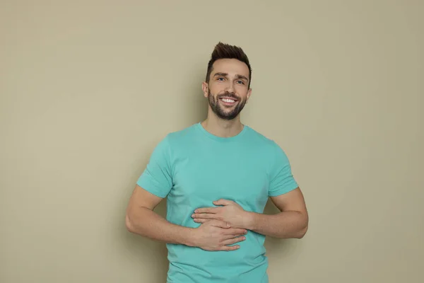 快乐的男人在米色背景下摸着自己的肚子 健康胃的概念 — 图库照片