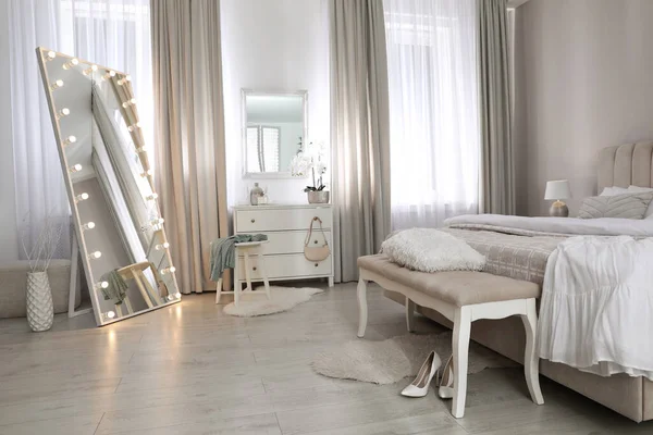 Yatak odasında ampulleri ve çekmeceleri olan büyük bir ayna. İç tasarım