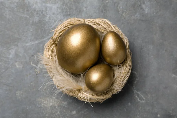 Gouden Eieren Nest Grijze Tafel Bovenaanzicht — Stockfoto