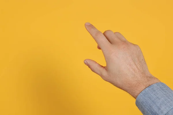 Homem Apontando Para Algo Contra Fundo Amarelo Perto Mão Espaço — Fotografia de Stock