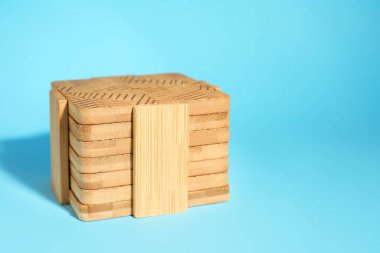 Açık mavi zemin üzerinde ahşap bardak altlıkları, metin için boşluk