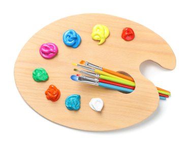 Beyaz arka planda boya ve fırçalı palet, üst manzara. Sanatçı ekipmanı