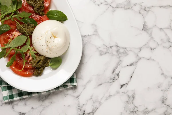 Lahodný Burrata Salát Rajčaty Rukolou Pesto Omáčkou Bílém Mramorovém Stole — Stock fotografie